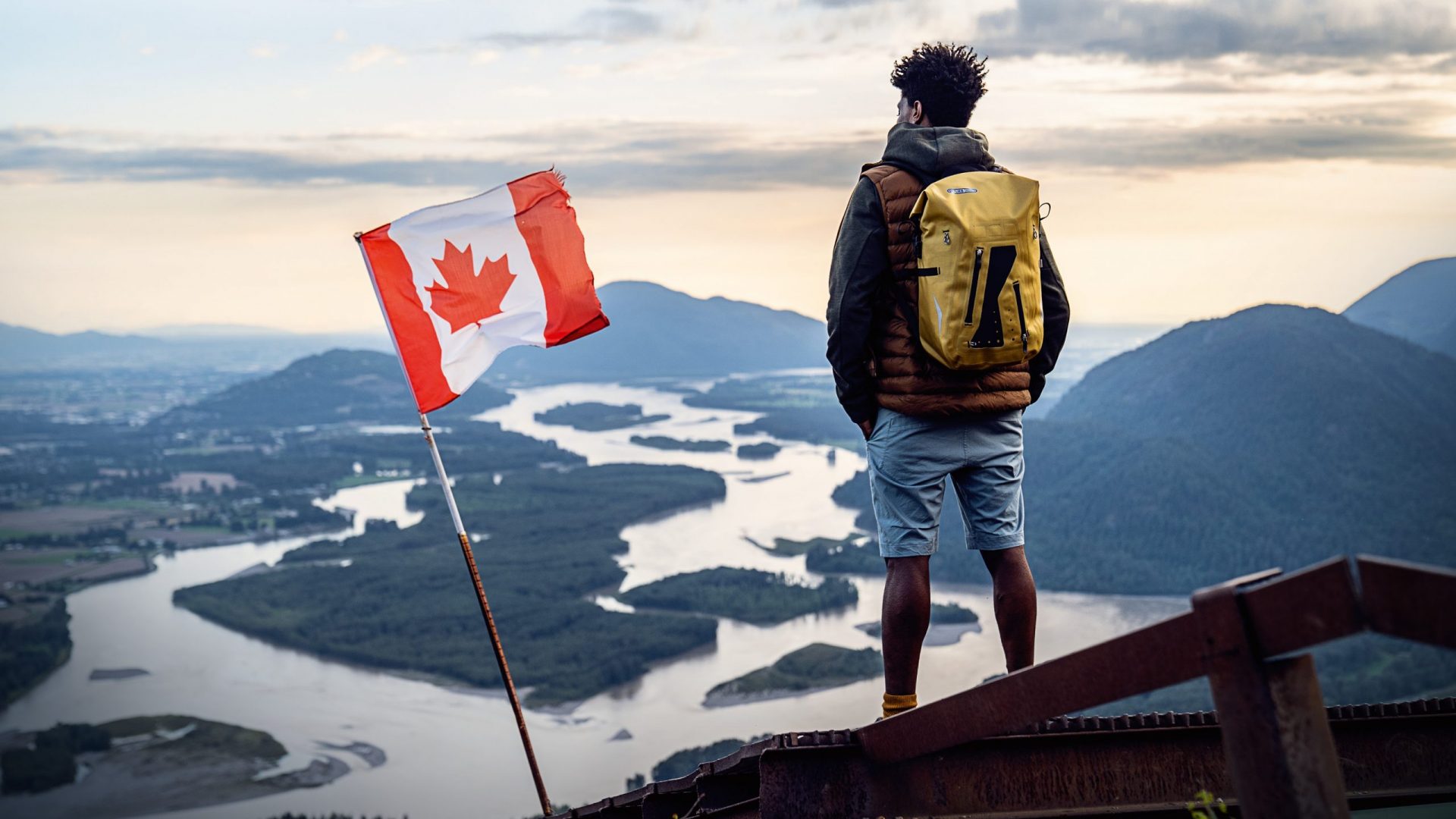 Ortlieb Fotoshooting auf einem Berg in Kanada und neben einer Kanada Flagge.