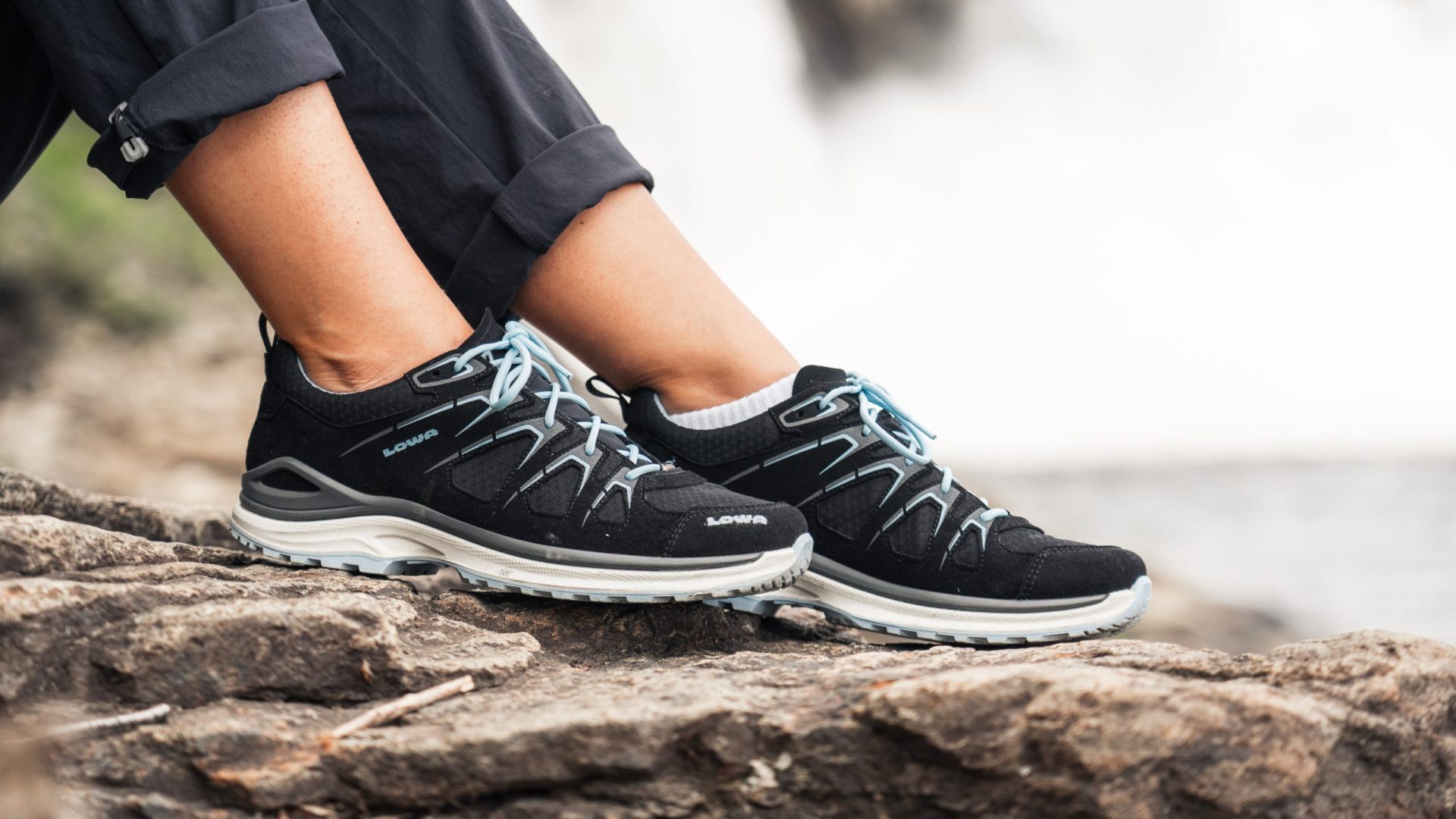 Fotoshooting mit einem Lowa Schuh vor einem Wasserfall.